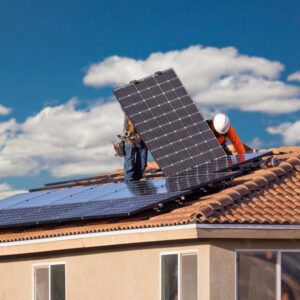 workers in Lincolnshire installing solar panels on house roof